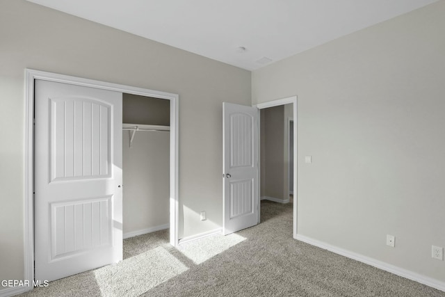 unfurnished bedroom with carpet flooring, baseboards, and a closet