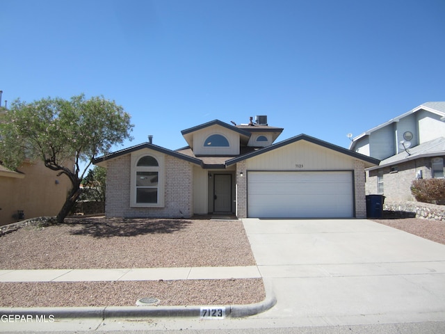 view of front of home featuring brick siding, a garage, and driveway