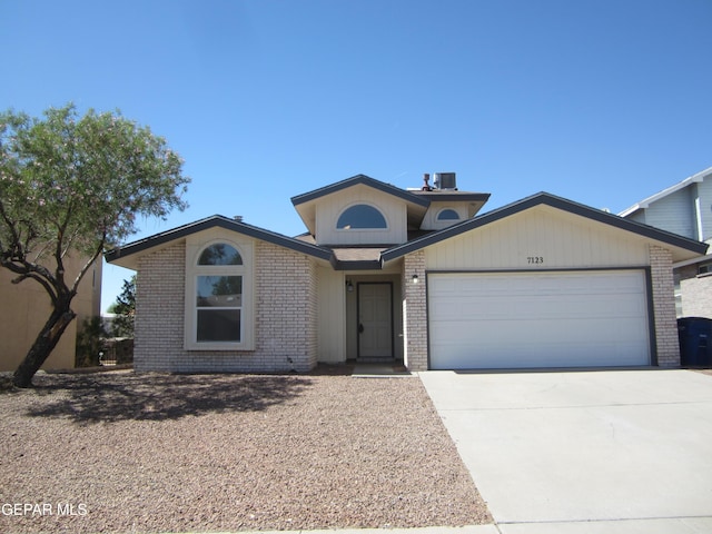 view of front of home with concrete driveway, brick siding, central air condition unit, and a garage