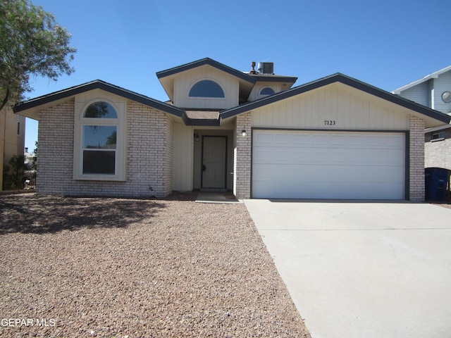 single story home featuring brick siding, a garage, central air condition unit, and driveway