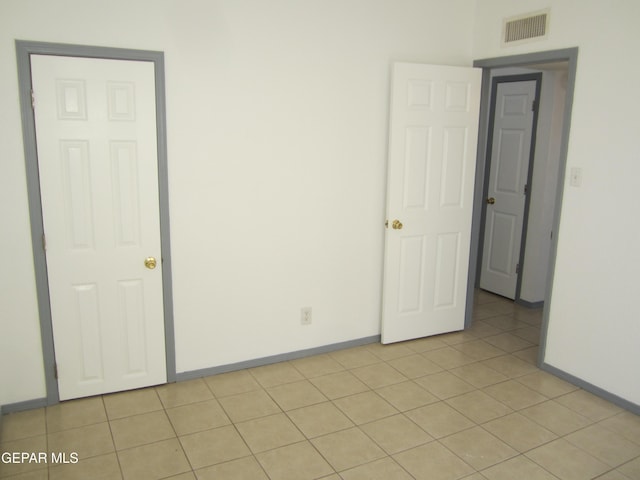spare room featuring light tile patterned floors, baseboards, and visible vents
