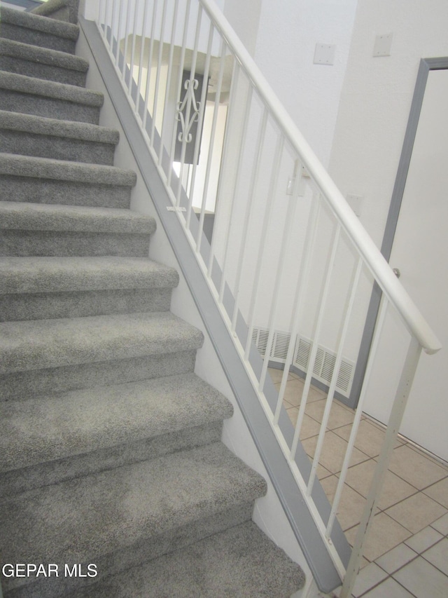 stairway with tile patterned floors