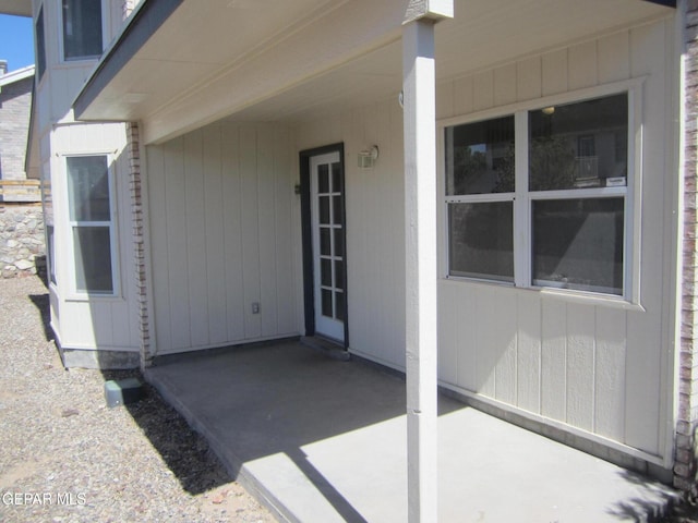 view of exterior entry with a patio area