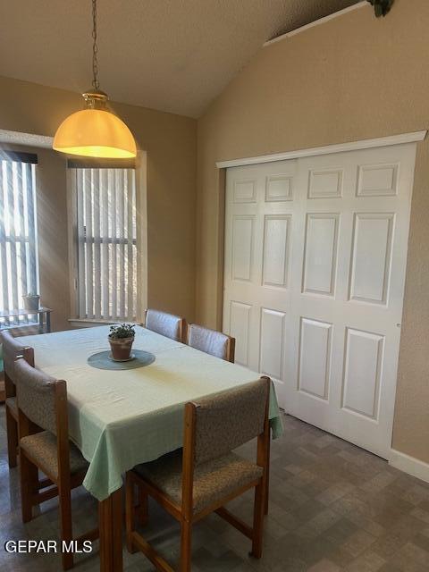 dining area with baseboards, tile patterned floors, and lofted ceiling