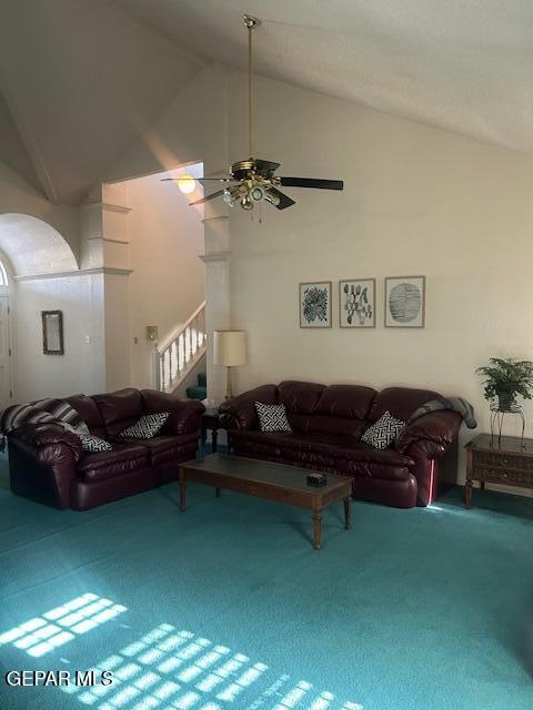 carpeted living area featuring high vaulted ceiling, ceiling fan, and stairway