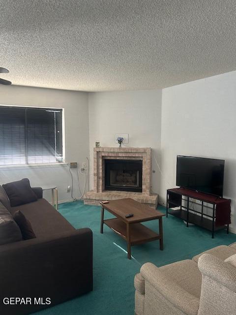 carpeted living area featuring a fireplace and a textured ceiling