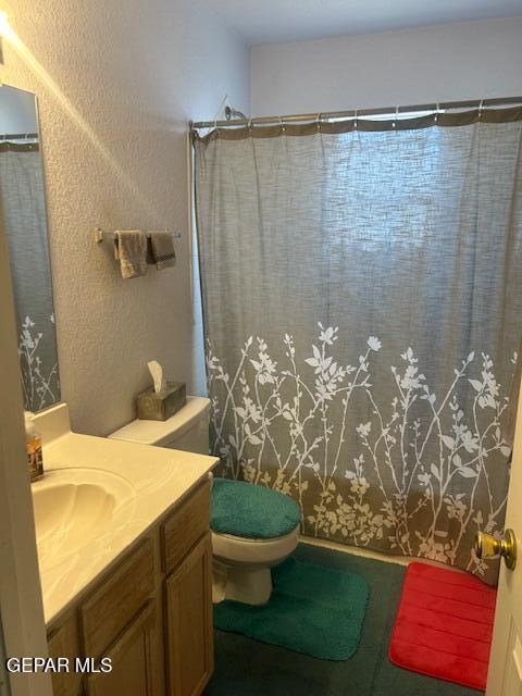 full bath with vanity, toilet, and curtained shower