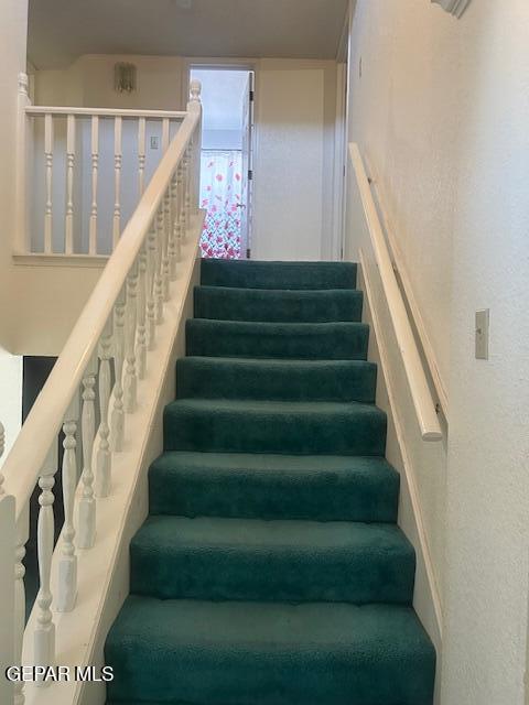 stairs featuring a textured wall
