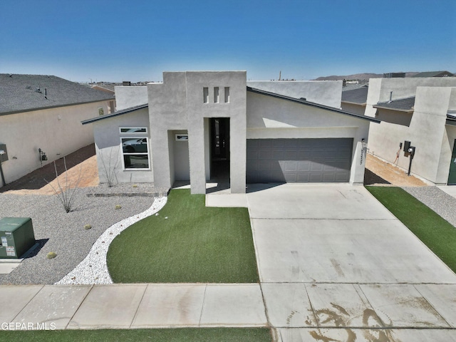contemporary house featuring concrete driveway, stucco siding, and a garage