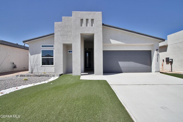 15237 Gauge Ct, El Paso, TX 79938 - contemporary house with a garage, stucco siding, driveway, and a front lawn