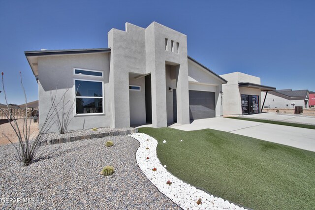 15237 Gauge Ct, El Paso, TX 79938 - modern home featuring an attached garage, driveway, and stucco siding