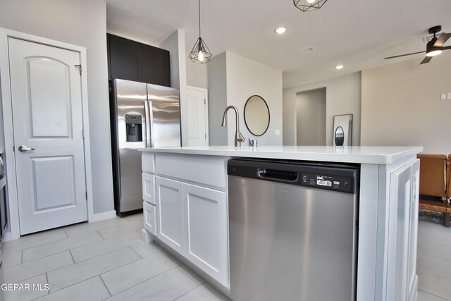 15237 Gauge Ct, El Paso, TX 79938 - kitchen with appliances with stainless steel finishes, light countertops, white cabinets, light tile patterned flooring, and an island with sink