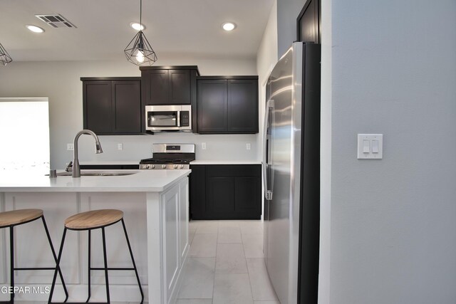 15237 Gauge Ct, El Paso, TX 79938 - kitchen with appliances with stainless steel finishes, a breakfast bar, a sink, light countertops, and visible vents