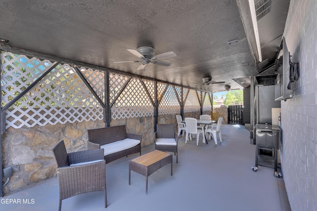 view of patio with fence, a ceiling fan, and outdoor dining area