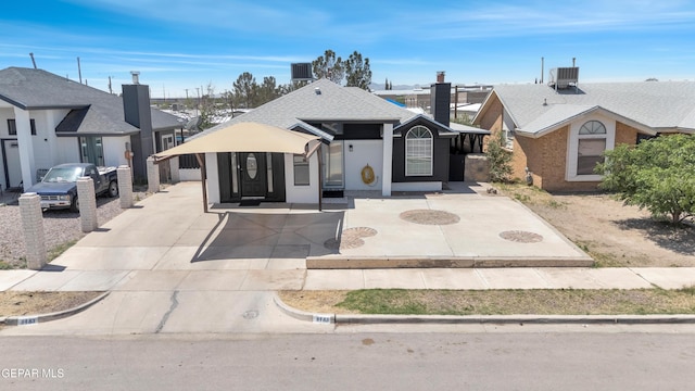 view of front of home featuring concrete driveway and central AC