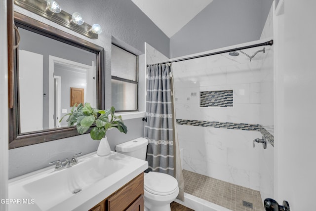full bath featuring vanity, toilet, lofted ceiling, a textured wall, and tiled shower