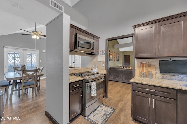 kitchen with dark brown cabinets, light wood-style floors, ceiling fan, backsplash, and stainless steel appliances