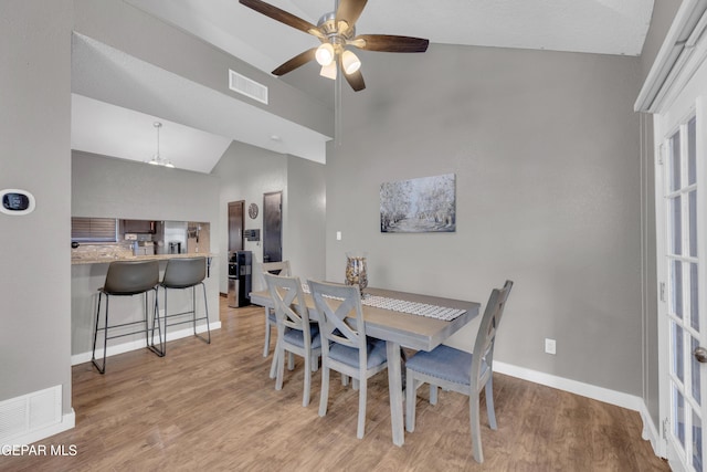 dining room with baseboards, visible vents, ceiling fan, and light wood finished floors