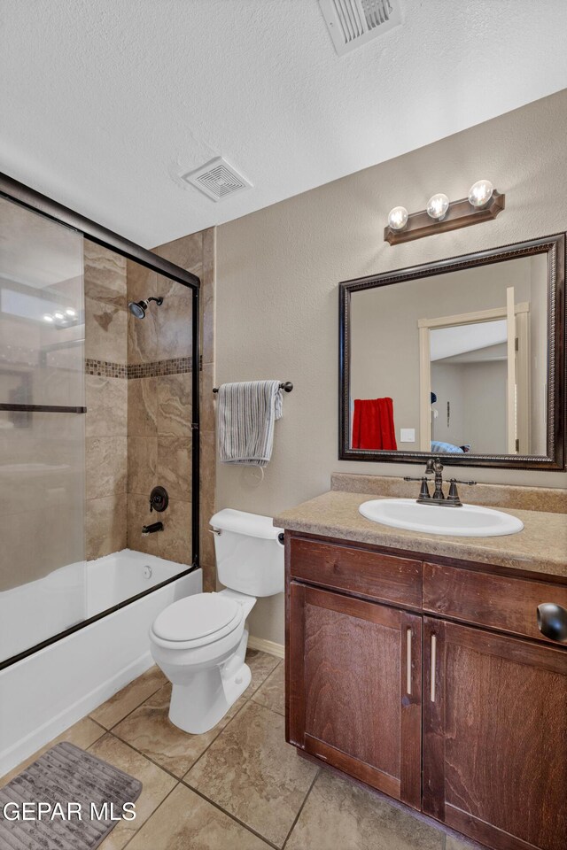 full bathroom with a textured ceiling, visible vents, vanity, toilet, and enclosed tub / shower combo