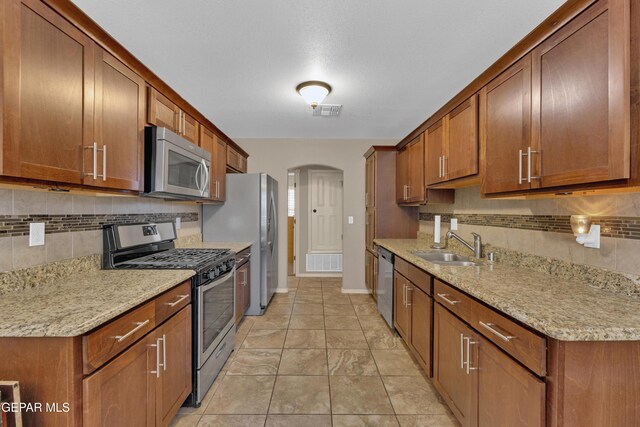 kitchen featuring a sink, backsplash, stainless steel appliances, and visible vents