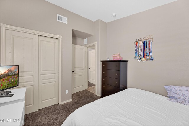 carpeted bedroom featuring visible vents, baseboards, and a closet