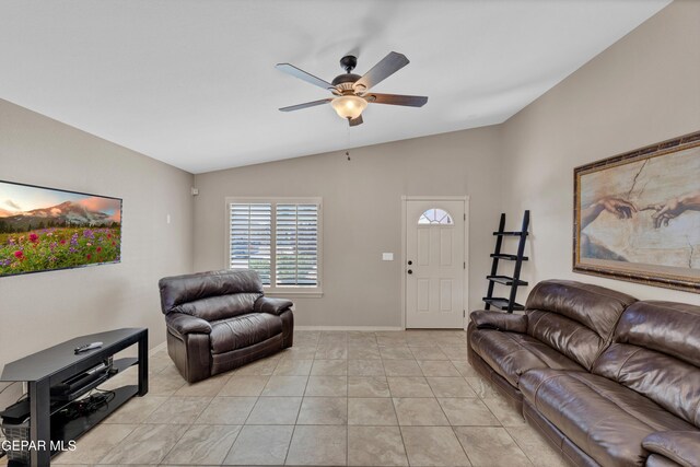 living area featuring baseboards, a ceiling fan, light tile patterned flooring, and vaulted ceiling