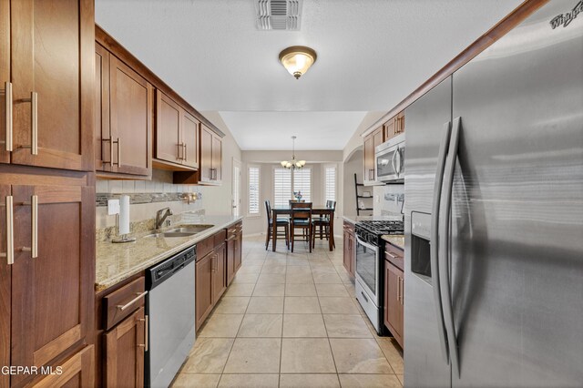 kitchen featuring visible vents, a chandelier, a sink, light tile patterned floors, and stainless steel appliances
