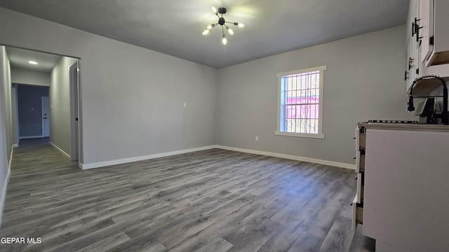 209 Hardesty Pl Unit 1 & 2, El Paso, TX 79905 - spare room featuring a chandelier, dark wood-type flooring, and baseboards