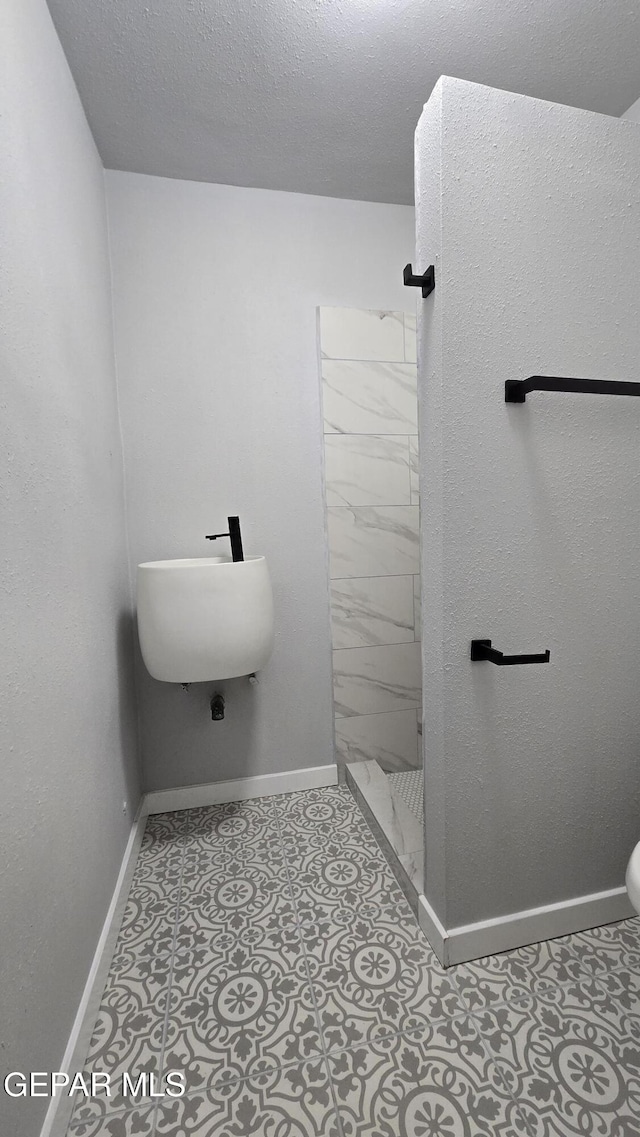 209 Hardesty Pl Unit 1 & 2, El Paso, TX 79905 - bathroom featuring a stall shower, baseboards, and toilet
