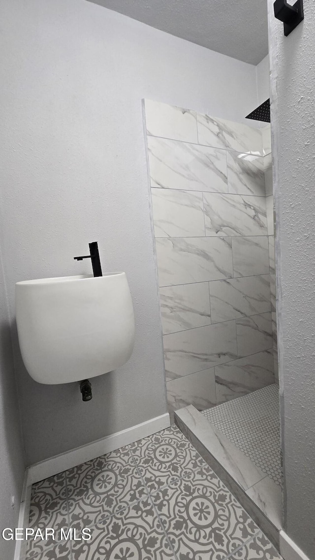 209 Hardesty Pl Unit 1 & 2, El Paso, TX 79905 - bathroom with tiled shower, baseboards, and a sink