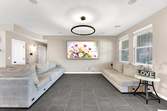 living room featuring dark tile patterned flooring, baseboards, and visible vents