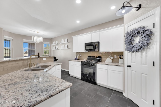 kitchen featuring backsplash, a sink, dark tile patterned flooring, white cabinets, and black appliances