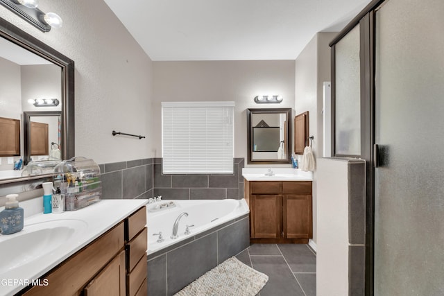 full bathroom with a sink, tile patterned flooring, a garden tub, and two vanities