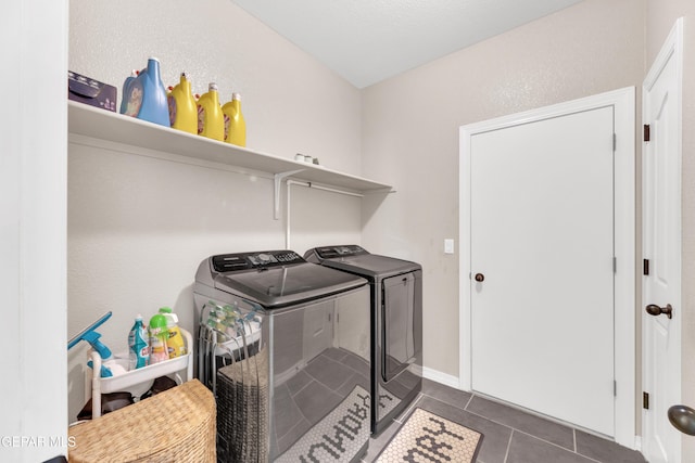 laundry room featuring independent washer and dryer, dark tile patterned flooring, and laundry area