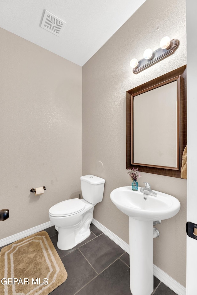 bathroom featuring visible vents, baseboards, tile patterned flooring, and toilet