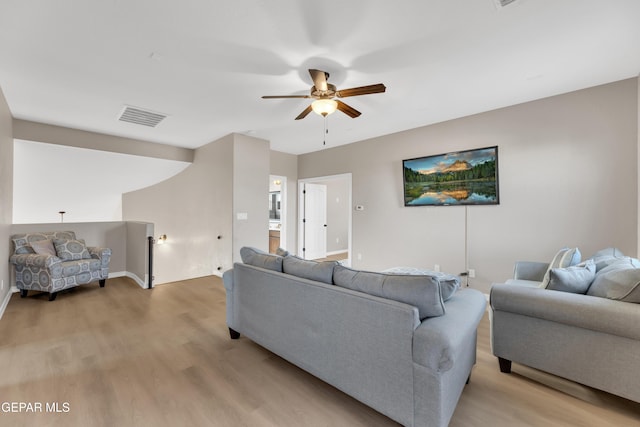 living room with a ceiling fan, visible vents, and light wood-style floors