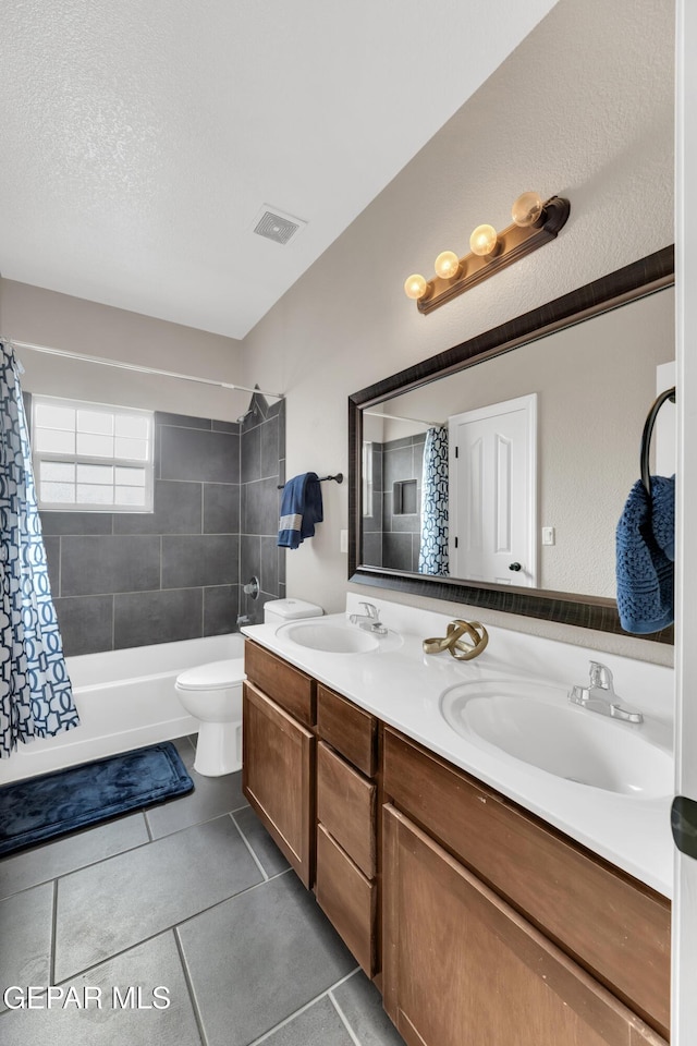 bathroom featuring a sink, tile patterned flooring, double vanity, and visible vents