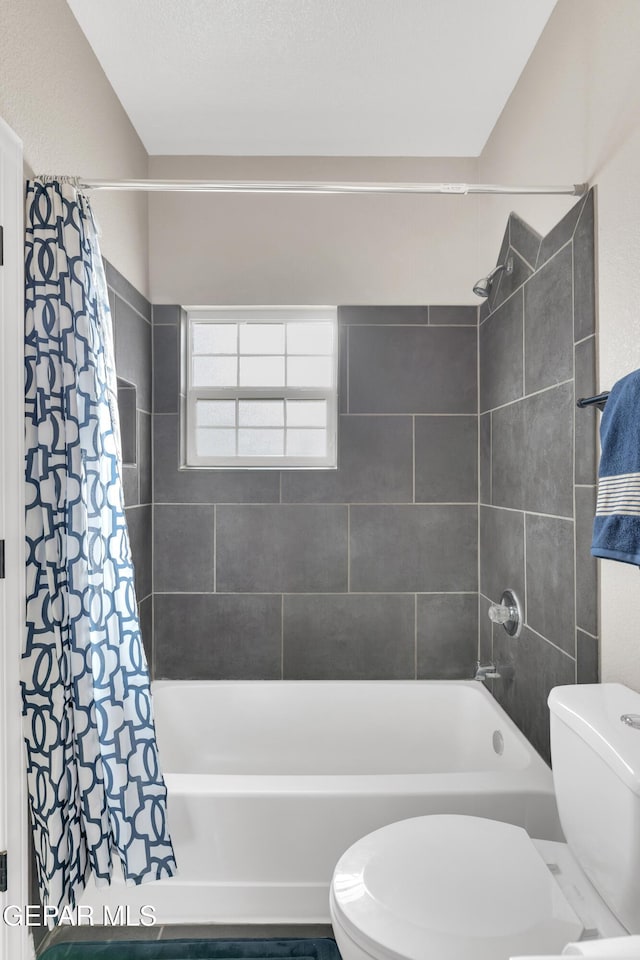 bathroom with shower / bath combo with shower curtain and toilet