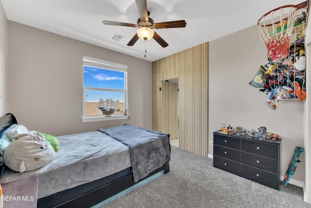 carpeted bedroom with a ceiling fan and visible vents