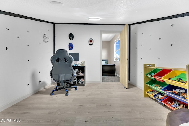 recreation room featuring a textured ceiling and wood finished floors