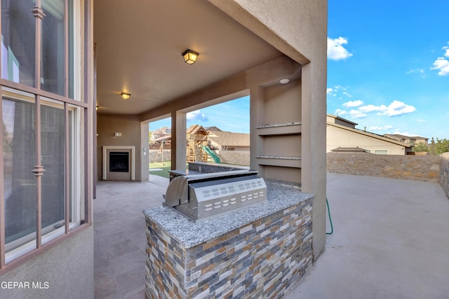 view of patio / terrace with a playground and exterior kitchen