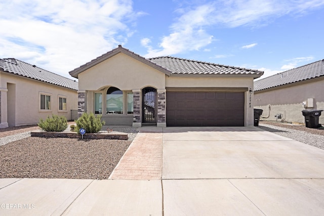 mediterranean / spanish-style house with an attached garage, stucco siding, a tiled roof, and concrete driveway
