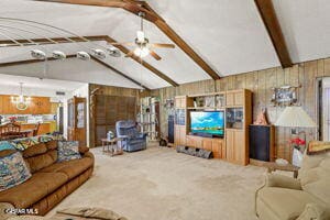 1421 Monte Negro Dr, El Paso, TX 79935 - living area featuring wood walls, carpet, lofted ceiling with beams, and ceiling fan with notable chandelier