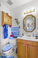 1421 Monte Negro Dr, El Paso, TX 79935 - half bathroom featuring visible vents, tile patterned flooring, toilet, and vanity