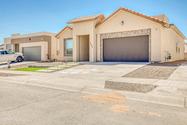 14940 Tierra Escape Ave, El Paso, TX 79938 - view of front of house featuring an attached garage, stucco siding, driveway, and a tiled roof