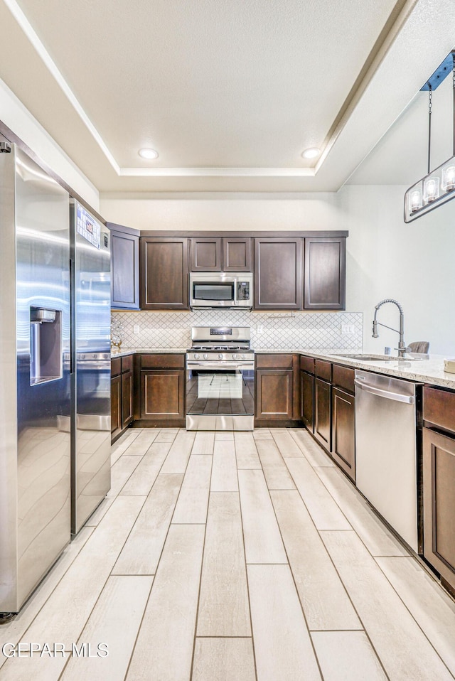 14940 Tierra Escape Ave, El Paso, TX 79938 - kitchen with a sink, decorative backsplash, dark brown cabinets, and stainless steel appliances