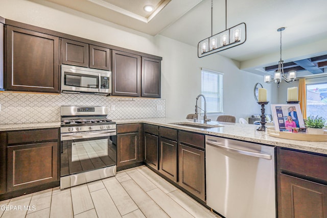 14940 Tierra Escape Ave, El Paso, TX 79938 - kitchen with stainless steel appliances, decorative backsplash, a sink, and dark brown cabinets