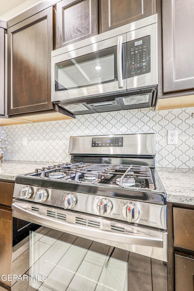 14940 Tierra Escape Ave, El Paso, TX 79938 - kitchen featuring appliances with stainless steel finishes, tasteful backsplash, dark brown cabinetry, and light stone counters