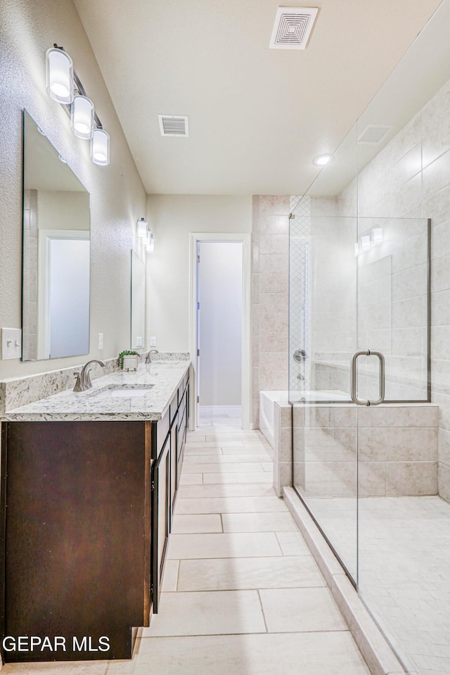 14940 Tierra Escape Ave, El Paso, TX 79938 - full bath featuring double vanity, a bath, visible vents, a shower stall, and a sink