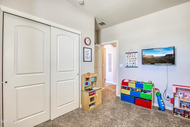 rec room with baseboards, visible vents, and carpet